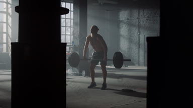 力量举重运动员举重锻炼健身房男人。执行前面蹲
